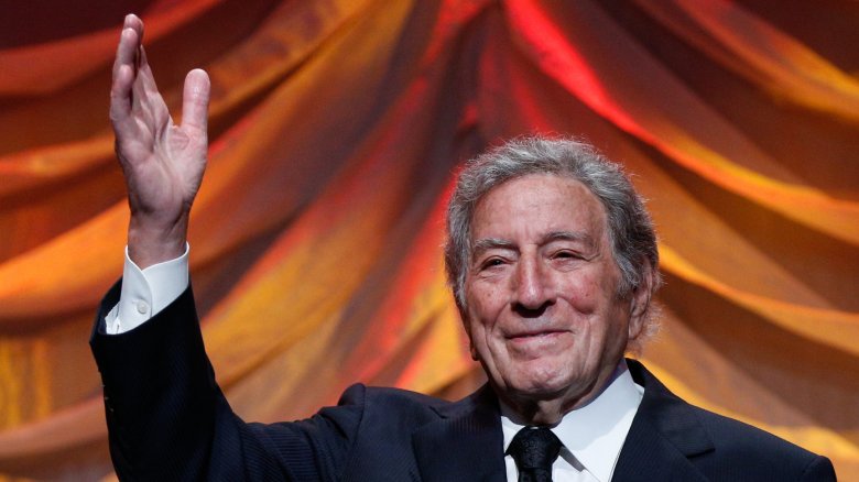 Tony Bennett faisant un signe de la main devant un rideau